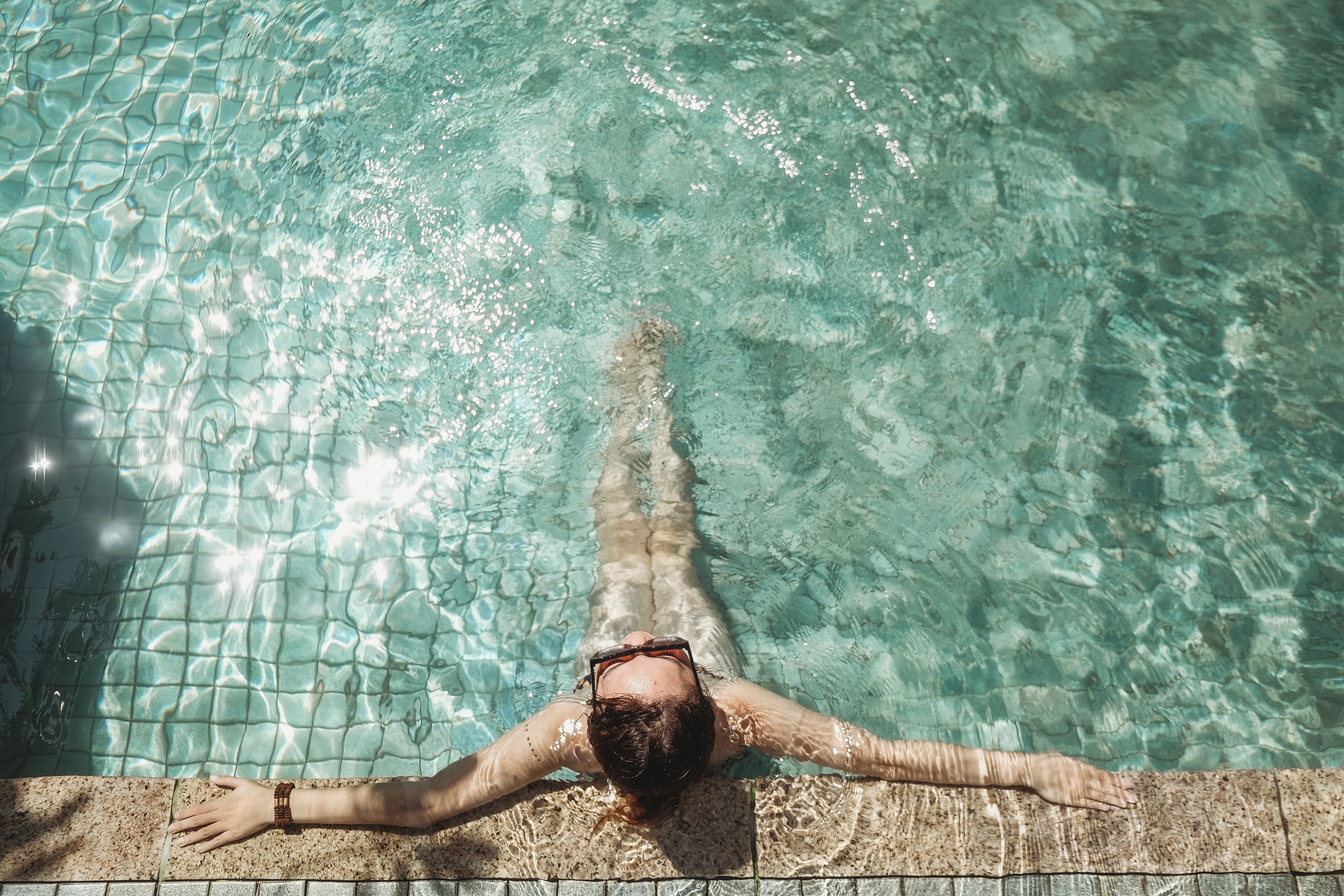 A woman with a bracelet relaxing in the pool.