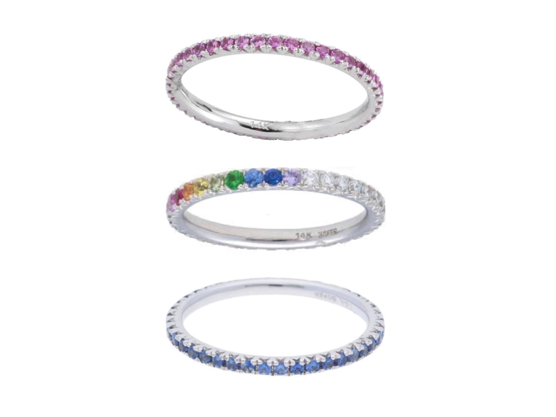 A ring stack in white gold with brightly colored gemstones. The bottom band is the Blue Sapphire Eternity Stackable Band by Deutsch Signature, the centerpiece ring is the Pavé Rainbow Eternity Stackable Band by Deutsch Signature, and the top ring is the Deutsch Signature Pink Sapphire Eternity Stackable Band, all available at Deutsch Fine Jewelry in Houston, Texas.