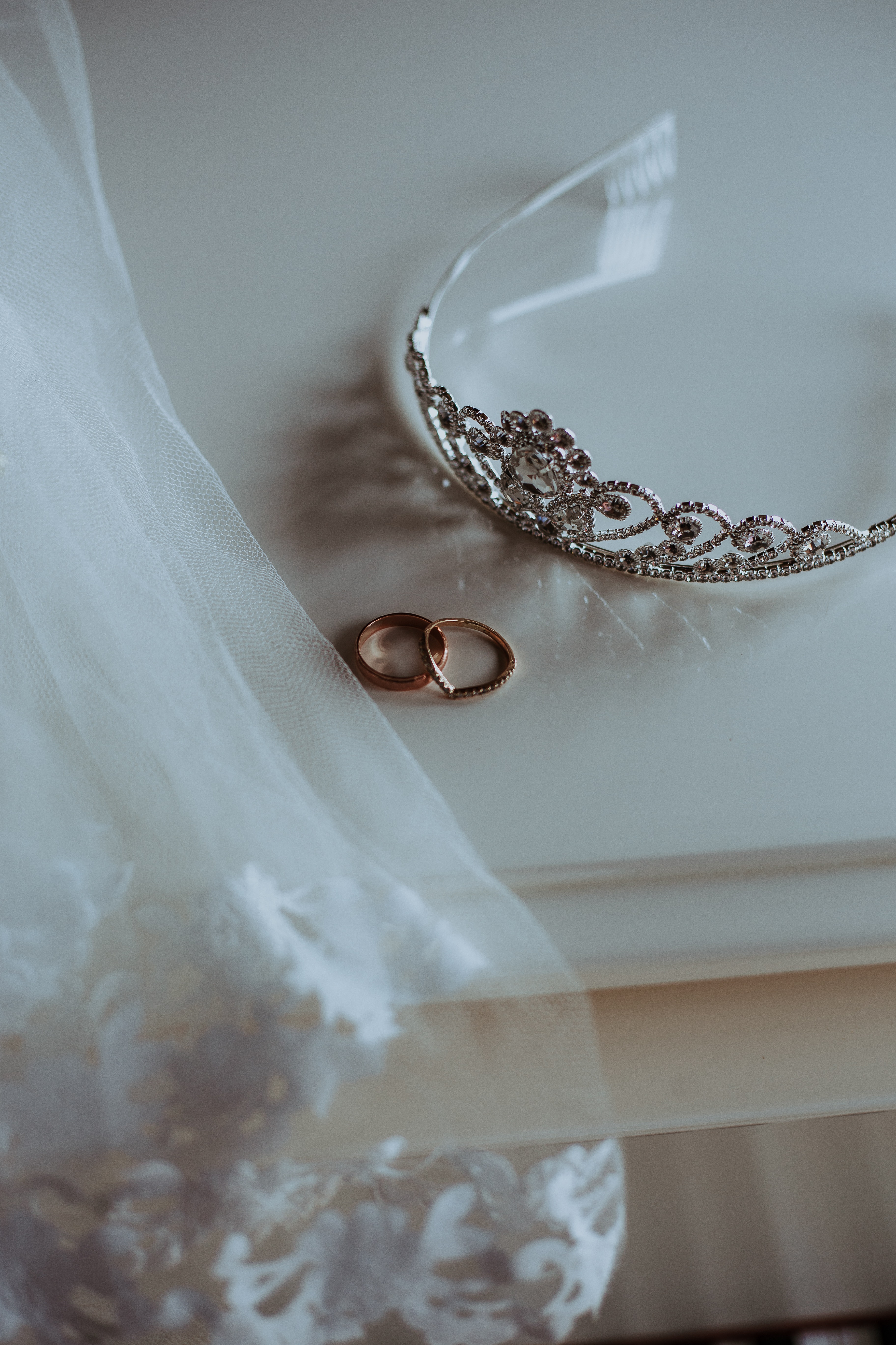 Silver Tiara with gold rings on a white tablecloth.