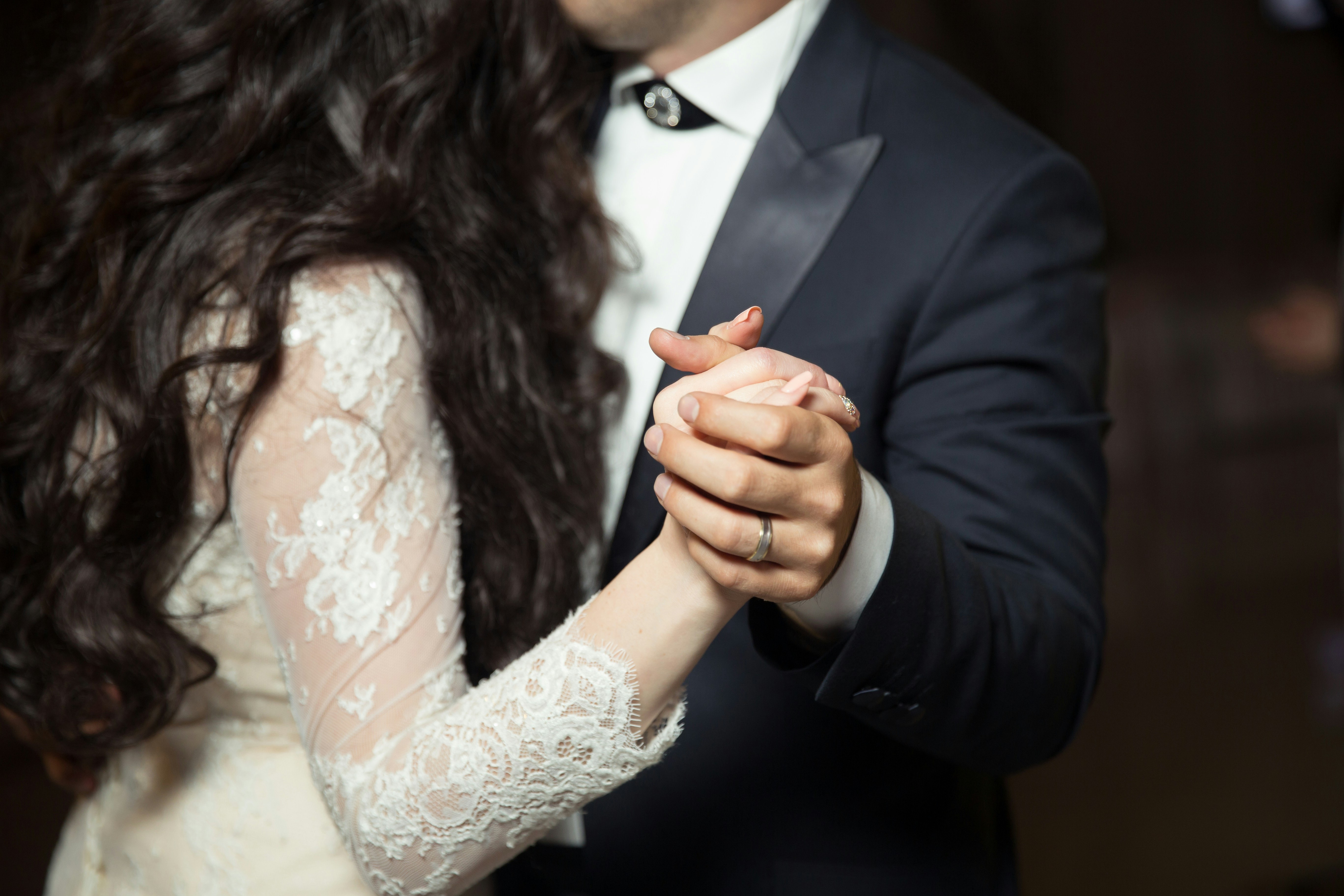 Photo by Alvin Mahmudov of a man wearing a wedding band and a woman dancing wearing formal dress via Unsplash  