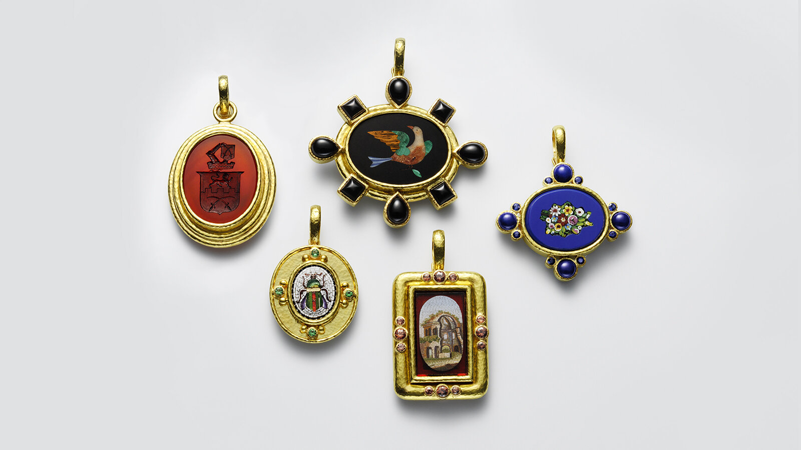 An assortment of yellow gold pendants with painting-like centerpieces, accented with colored gemstones.